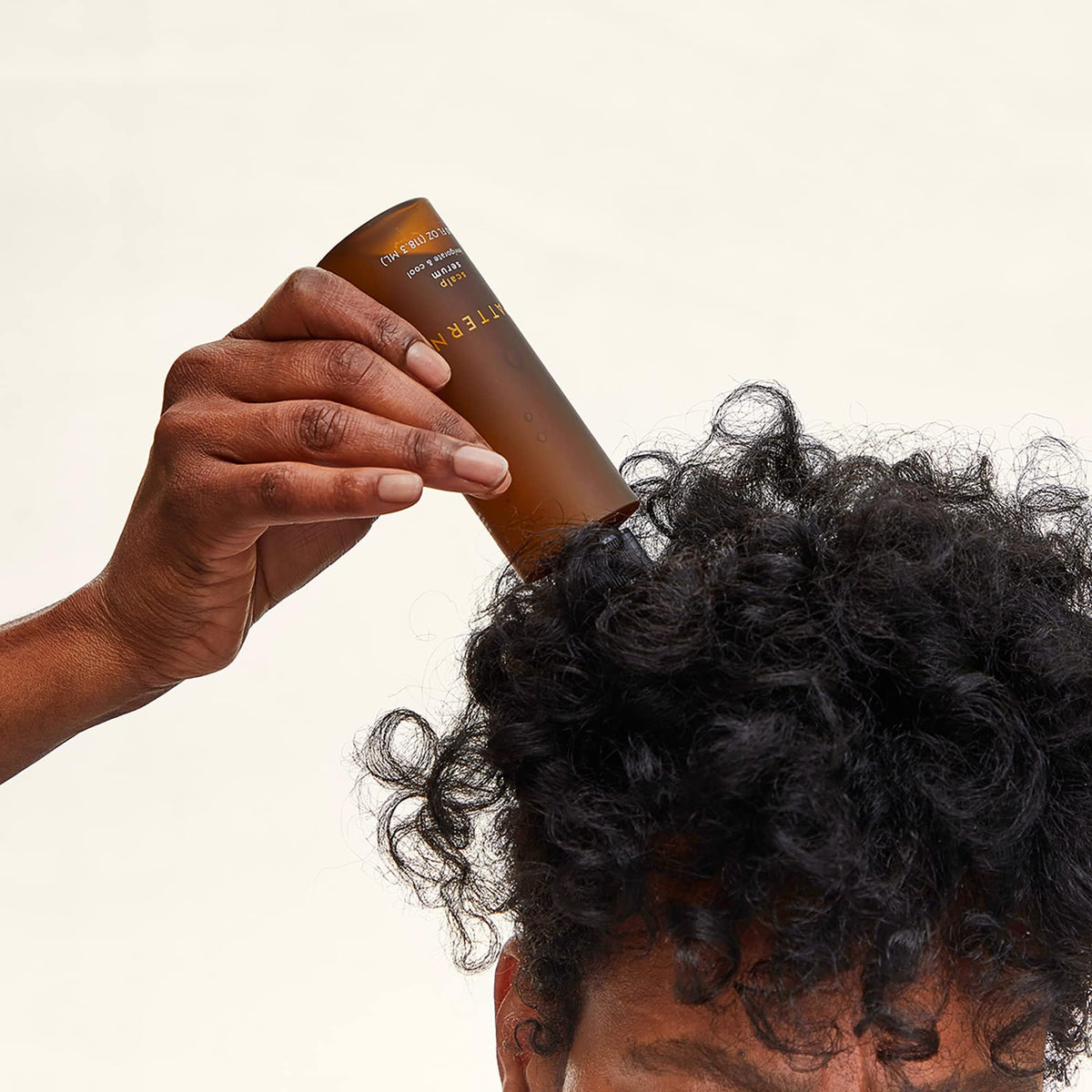 PATTERN scalp serum nozzle applying drops to a parting to show targeted root application and relief
