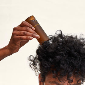 PATTERN scalp serum nozzle applying drops to a parting to show targeted root application and relief