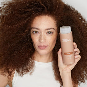 Paul Mitchell 33.8 fl oz bottle next to a ruler for scale and value-per-ounce context