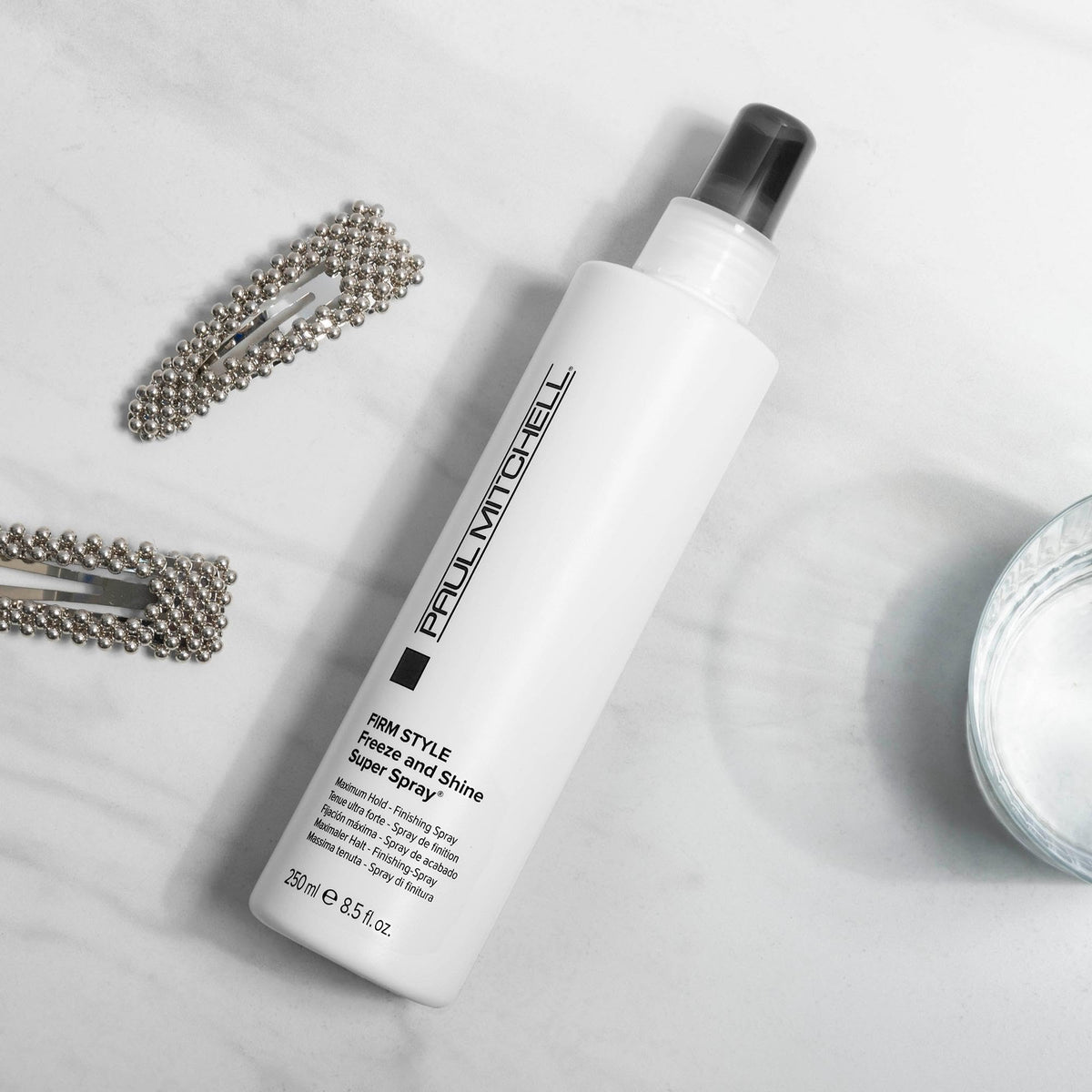 Paul Mitchell bottle in hand showing 3.4 fl oz size and portability