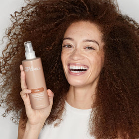 Paul Mitchell bottle held in hand to show 8.5 fl. oz. size and portability
