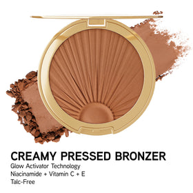 Physicians Formula bronzer on a vanity with summer props showing radiant, warm makeup look