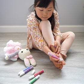 Piggy Paint pens in child's hand demonstrating easy, mess-free control