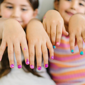 Hand holding Piggy Paint bottle to illustrate size and travel-friendly volume