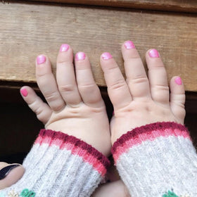 Piggy Paint size comparison with adult hand showing compact travel-friendly set