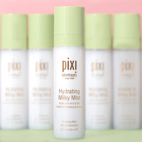 Pixi Milky Mist next to a smartphone showing portable 2.7 fl oz size