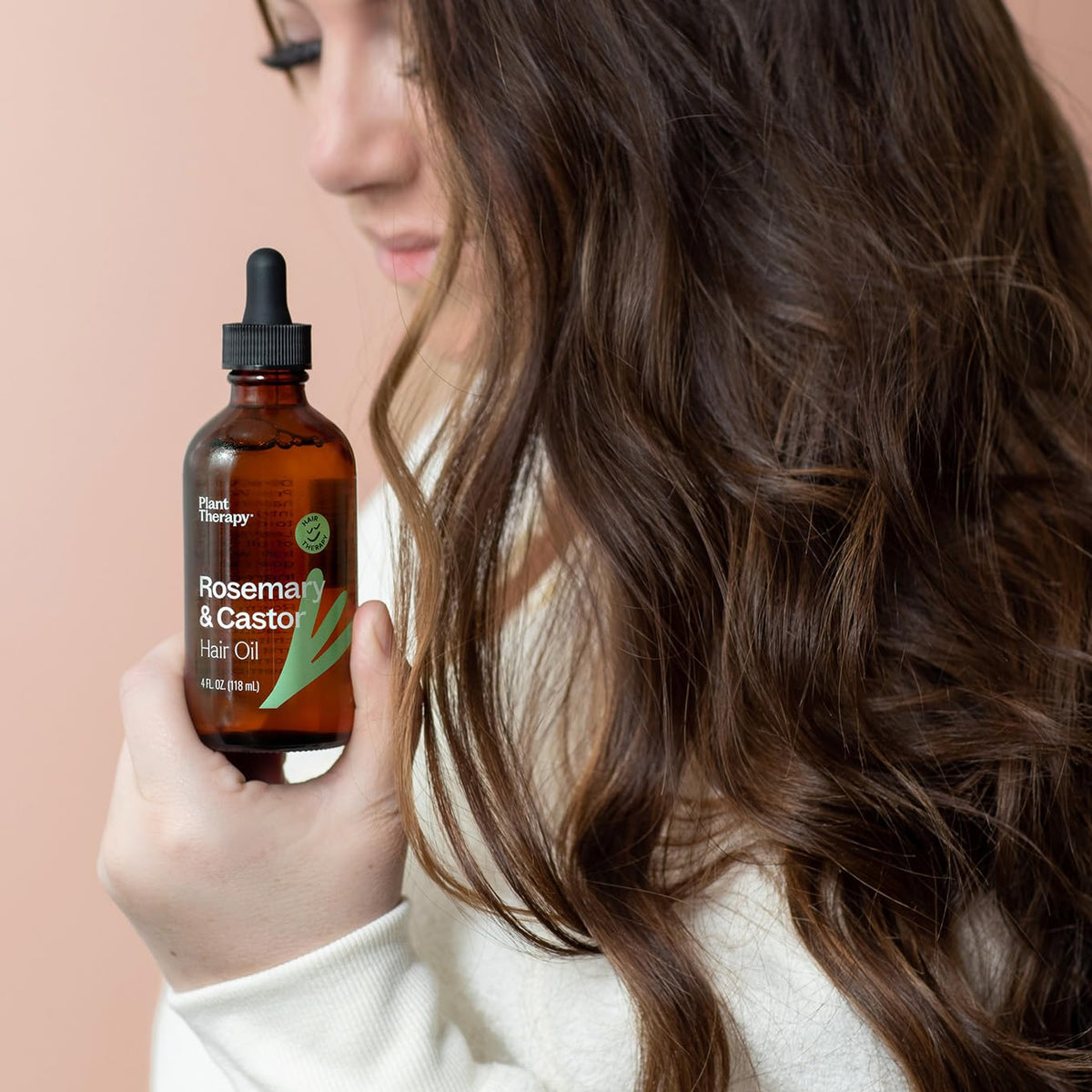 Applying Plant Therapy oil to scalp during massage to support healthy-feeling scalp