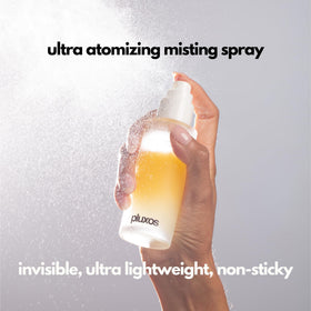 PLUXOS clear mist sprayed into hand showing fast-drying hydration