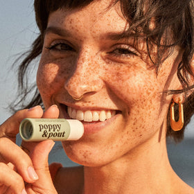 Poppy & Pout balm texture swirl on fingertip showing nourishing emollient benefit