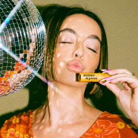 Poppy & Pout lifestyle outdoors applying balm for lip protection benefit