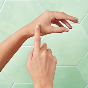 Proactiv single patch held by hand showing size and easy use