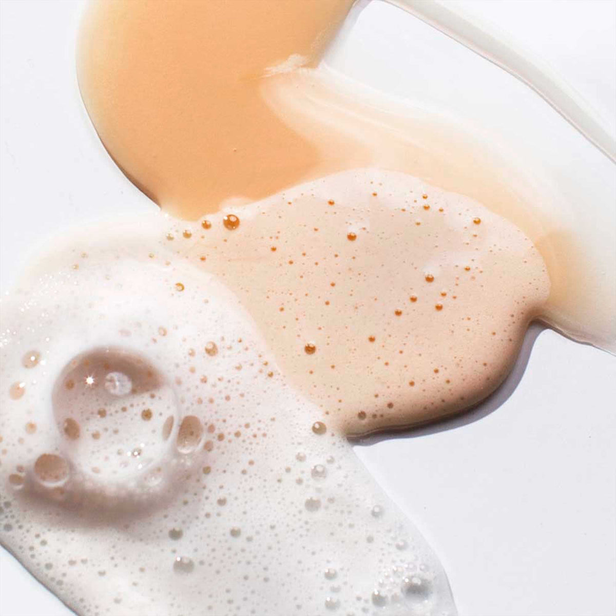 Pureology Nanoworks Gold being applied to wet hair in shower, shows effective cleansing and softness