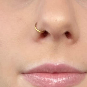 QWALIT lifestyle shot of person preparing nostril for piercing for confident self-use benefit