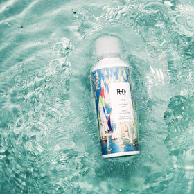 R+Co Sail being sprayed into hair for soft, touchable waves
