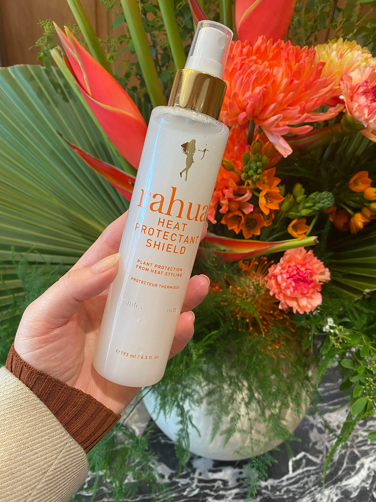 Rahua spray on hair strand close-up to show cuticle smoothing and moisture-sealing benefit