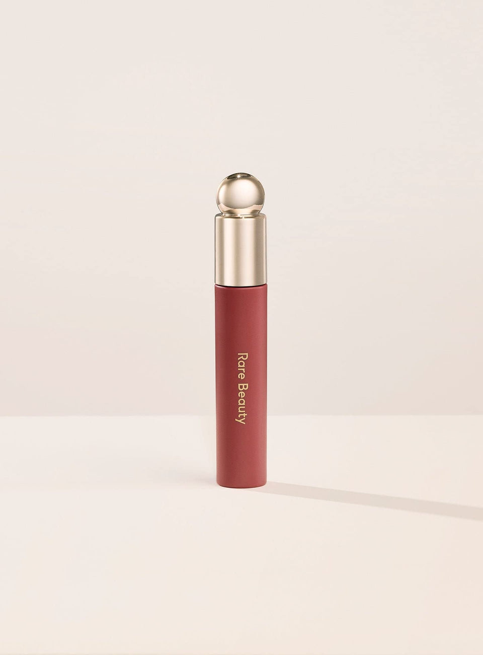 Rare Beauty bottle front view showing sleek packaging and glossy tint benefit