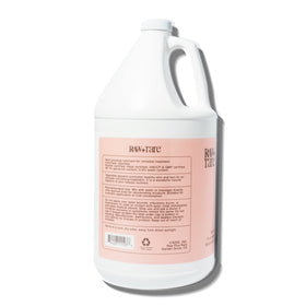 Raw Plus Rare gallon held by hand to show scale and convenient carry handle benefit