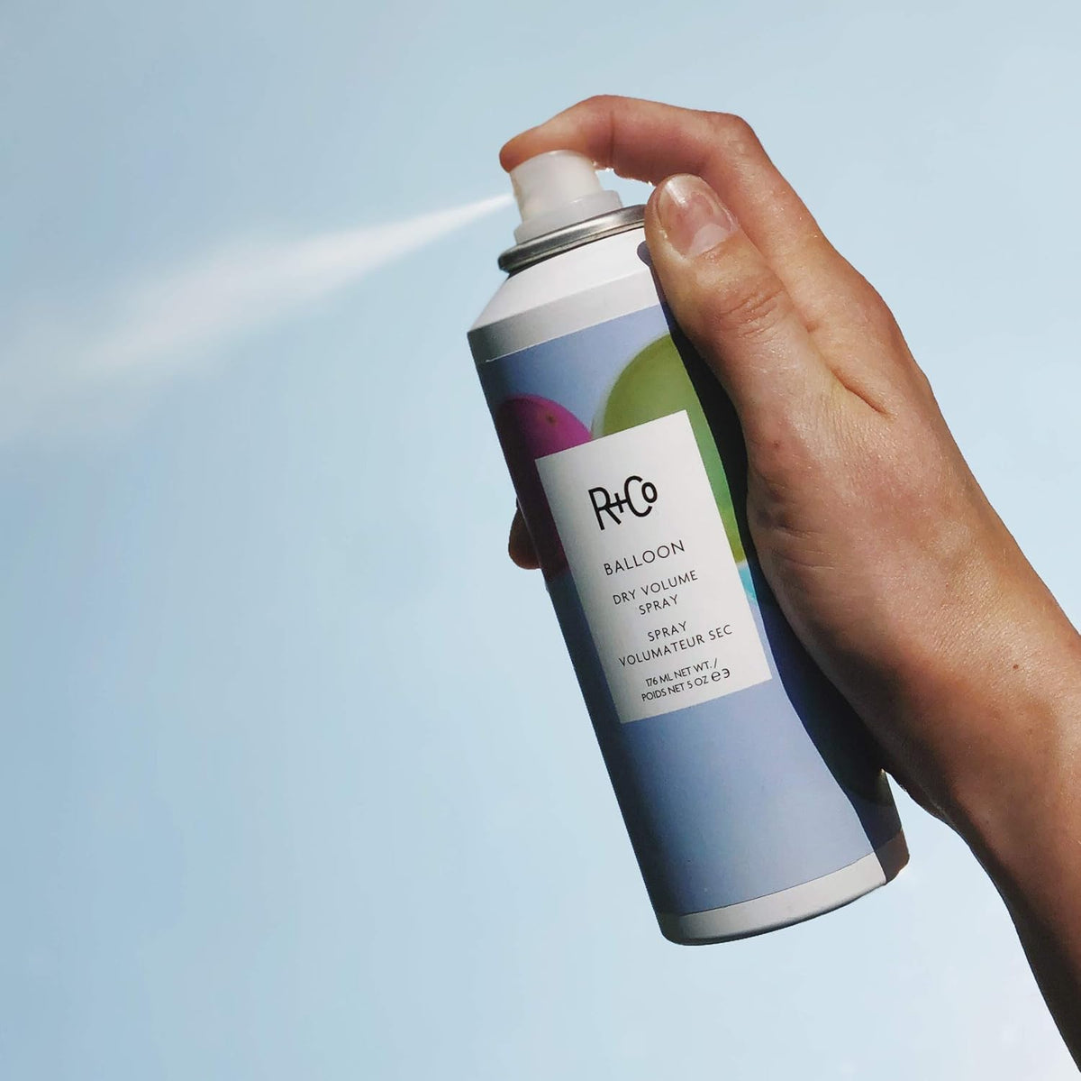 R+Co size in hand showing 5oz portability and travel-friendly benefit