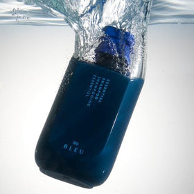 R+Co BLEU bottle held in hand to show 8.5 oz scale and travel‑friendly portability