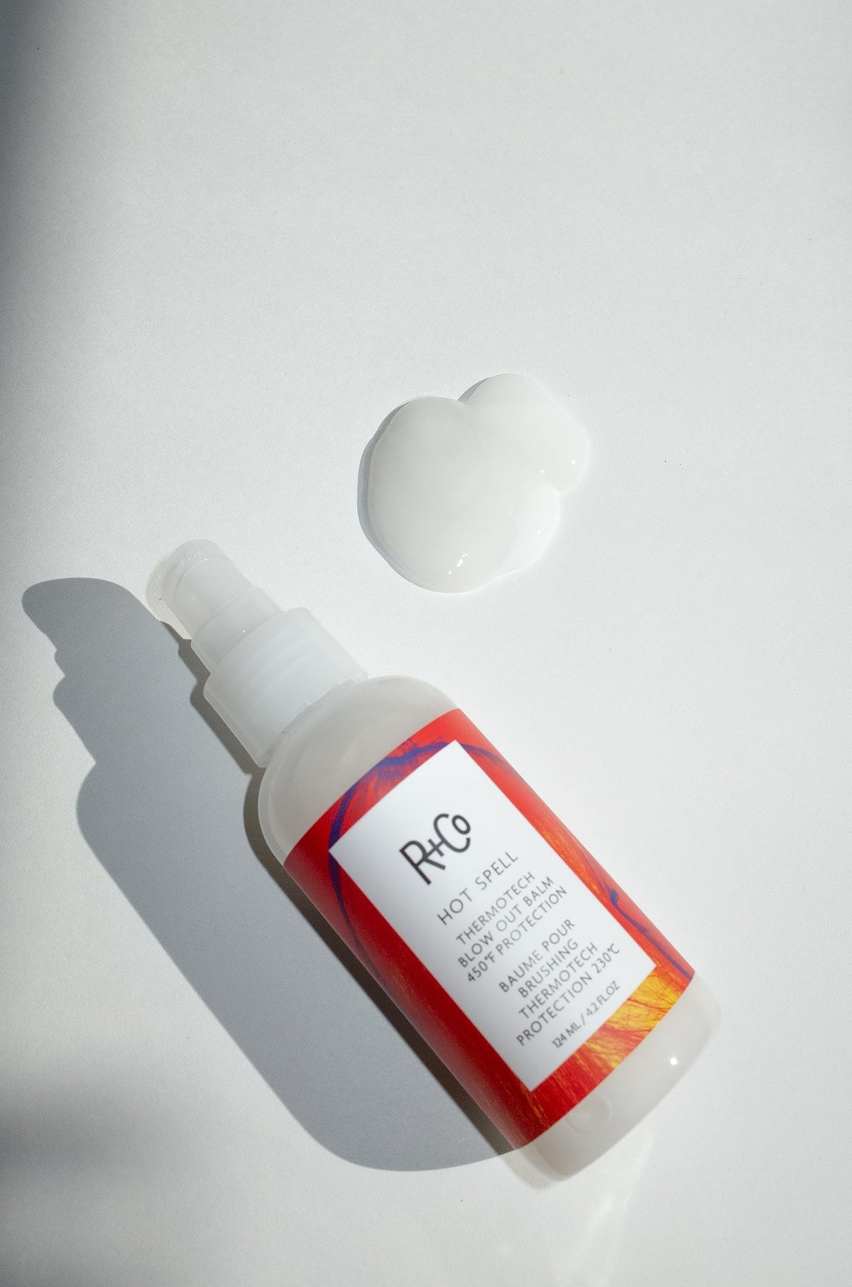 R+Co Hot Spell balm texture closeup demonstrating silky transformation and smoothness