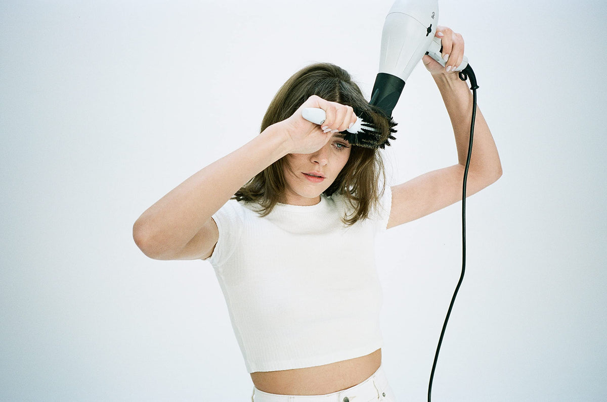R+Co Mood Swing used during blow-dry showing smoother hair and reduced frizz in action