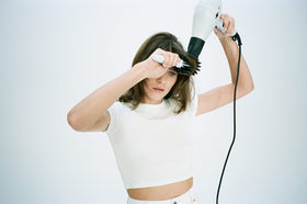 R+Co Mood Swing used during blow-dry showing smoother hair and reduced frizz in action
