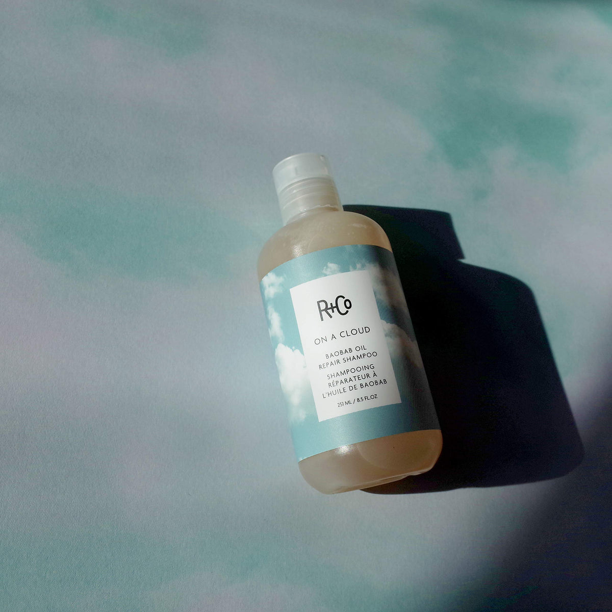 R+Co shampoo being applied in shower demonstrating gentle cleansing