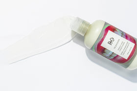 R+Co Television conditioner next to a ruler showing 8.5 oz size and travel-friendly benefit