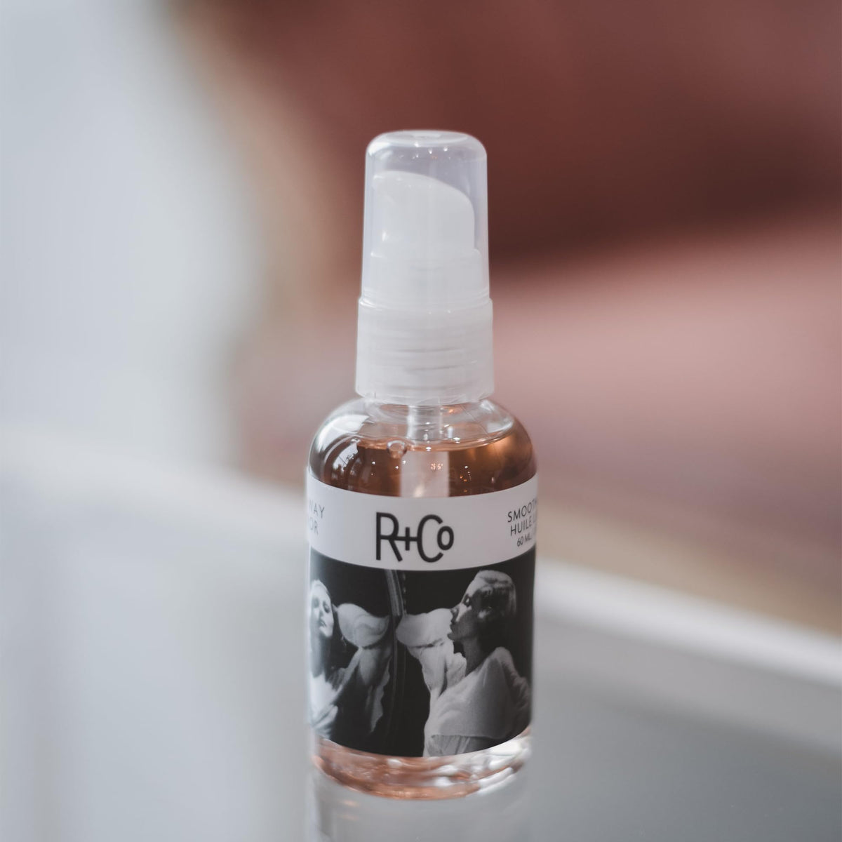 R+Co Two Way Mirror pouring oil from bottle demonstrating easy application