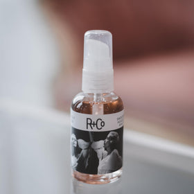 R+Co Two Way Mirror pouring oil from bottle demonstrating easy application