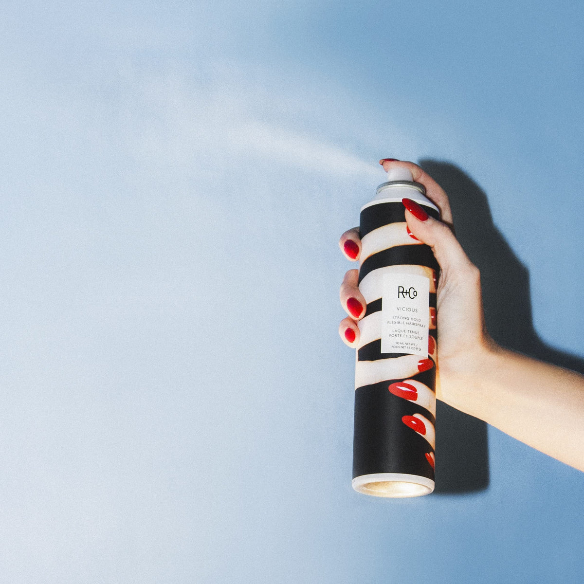 R+Co Vicious in use by stylist locking an updo for long-lasting, touchable hold