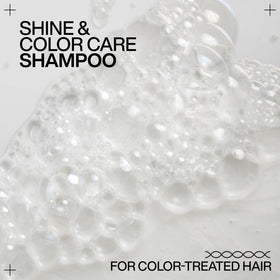 Redken bottle on salon counter by mirror, conveys professional shine results