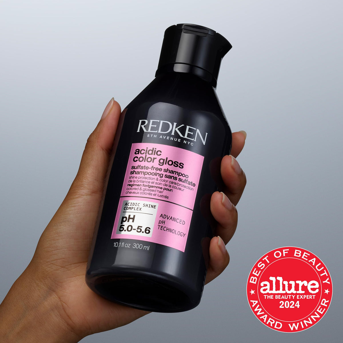 Size comparison of Redken bottle next to palm, demonstrates compactness