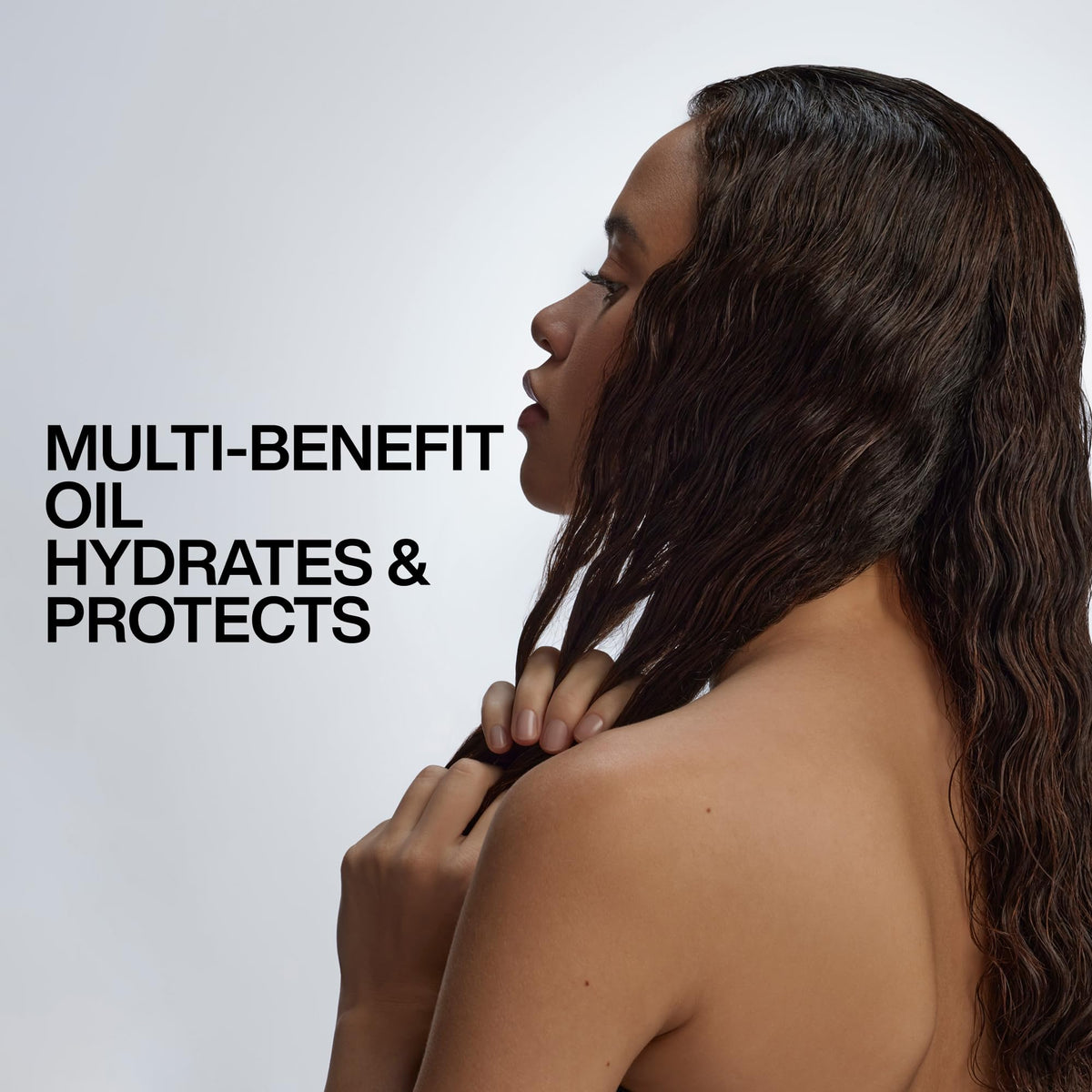 Redken travel-size oil in a toiletry bag showing portability and on-the-go care