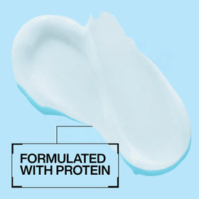 Redken mask beside hand shows 8.5 fl oz scale for portion guidance