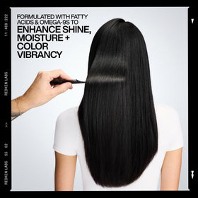 Redken on model with shiny hair illustrating color vibrancy benefits