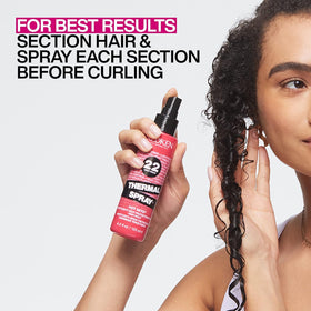 Redken bottle held in hand for scale demonstrating travel-friendly size
