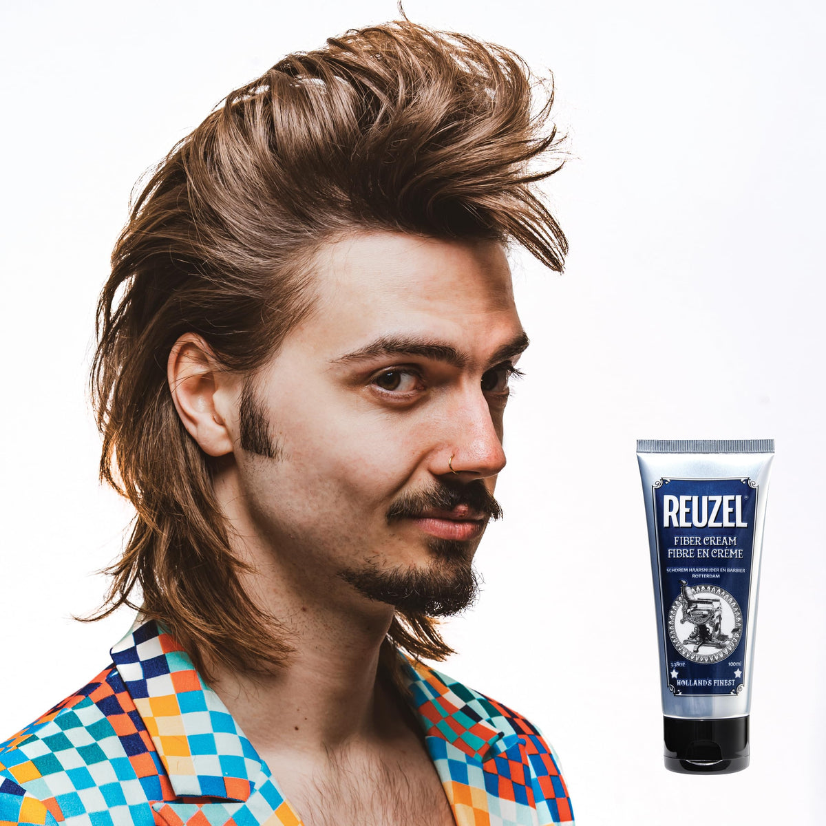 REUZEL in barber shop setting with stylist finishing client hair for professional result