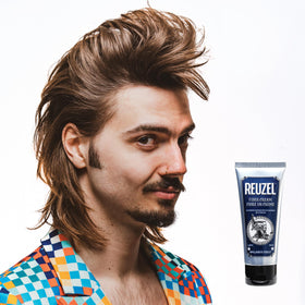 REUZEL in barber shop setting with stylist finishing client hair for professional result