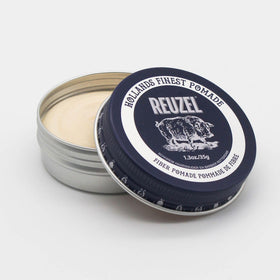 REUZEL texture closeup of pomade on fingers, displays pliable, matte styling benefit