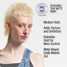 REUZEL pomade beside comb and towel indicating travel-friendly size