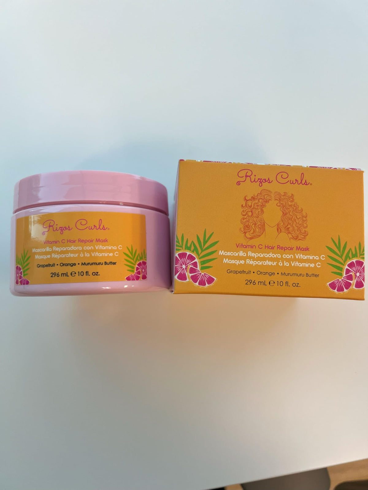Rizos Curls in hand detangling hair, demonstrating smoother strands