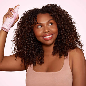 Rizos Curls spraying onto curly hair for defined bounce