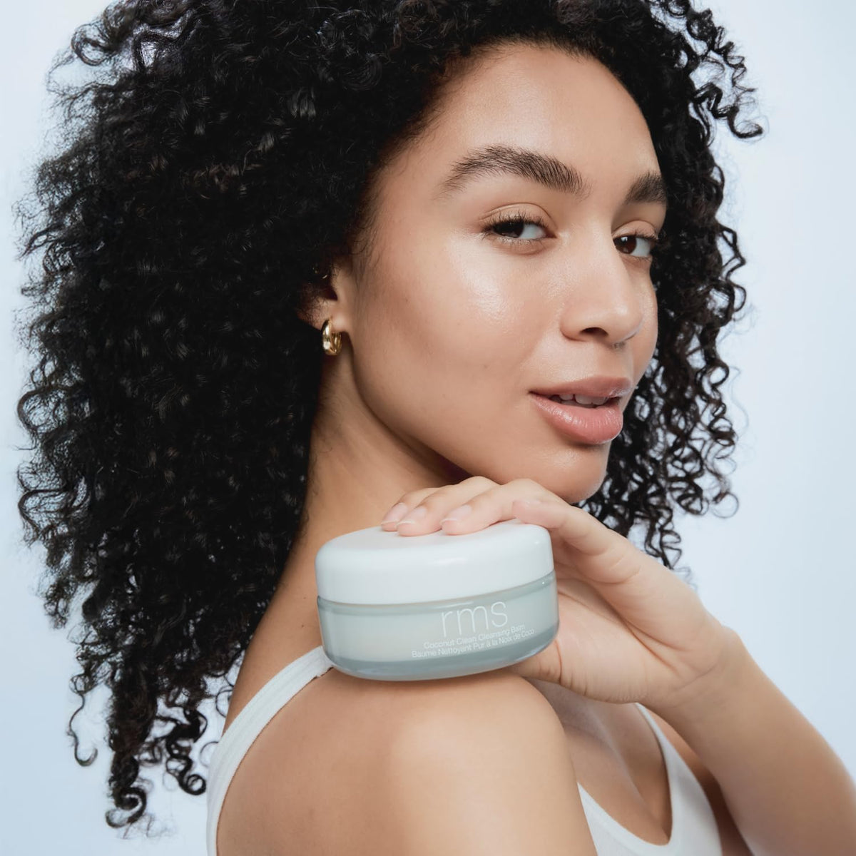 RMS Beauty melting balm in hand to show easy makeup removal