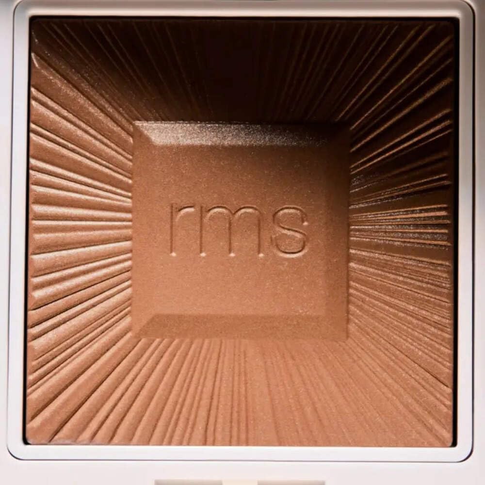RMS Beauty hydra bronzer being applied with brush for seamless contouring
