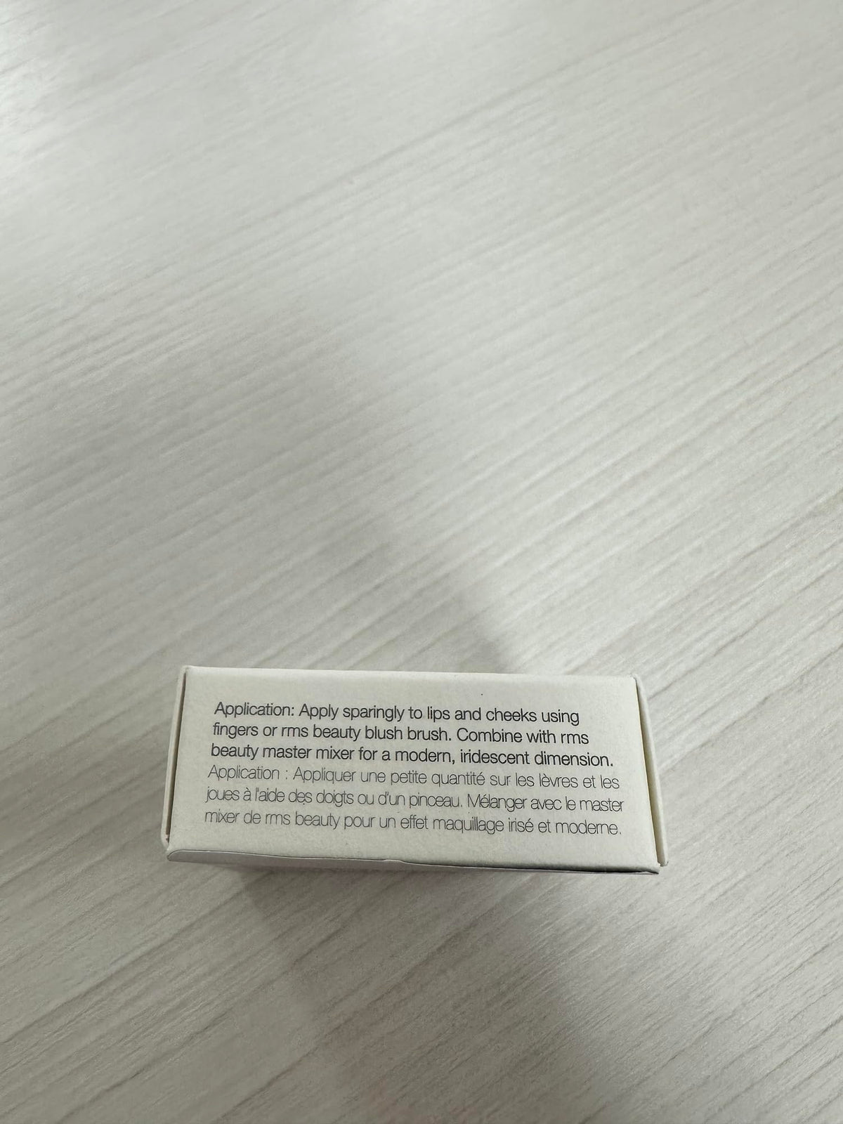 RMS Beauty compact beside a coin showing travel-friendly size and portability