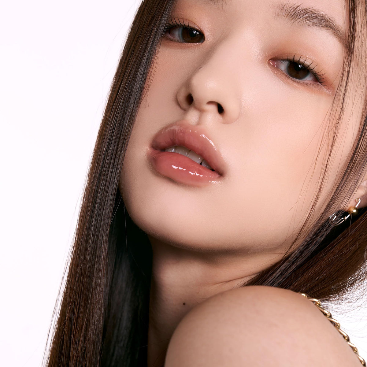 rom&nd gloss Peony Ballet in a handbag lifestyle shot suggesting everyday portability and quick touch-ups