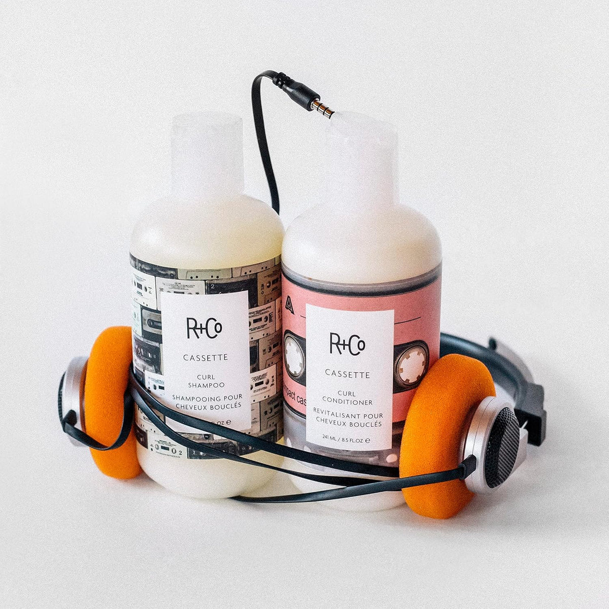 R+Co Cassette conditioner applied to curly hair in hand, illustrating detangling benefit