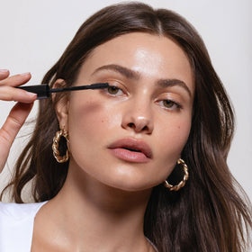 Saie mini mascara in a handbag lifestyle shot for on-the-go convenience