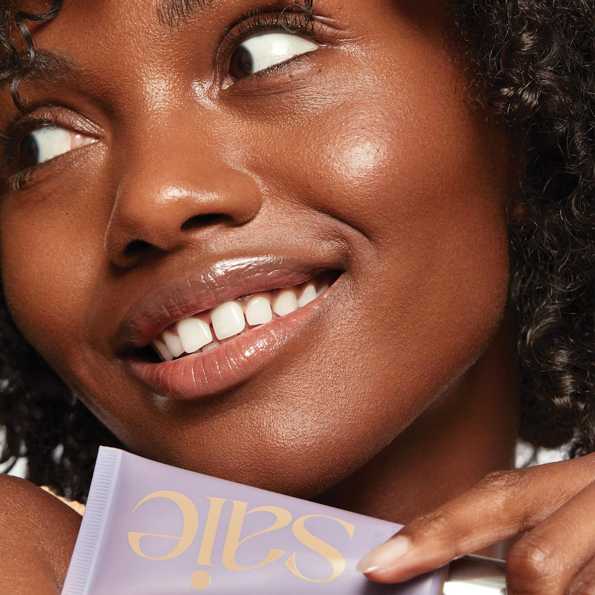 Saie Sunvisor spread on cheek showing sheer radiant finish benefit